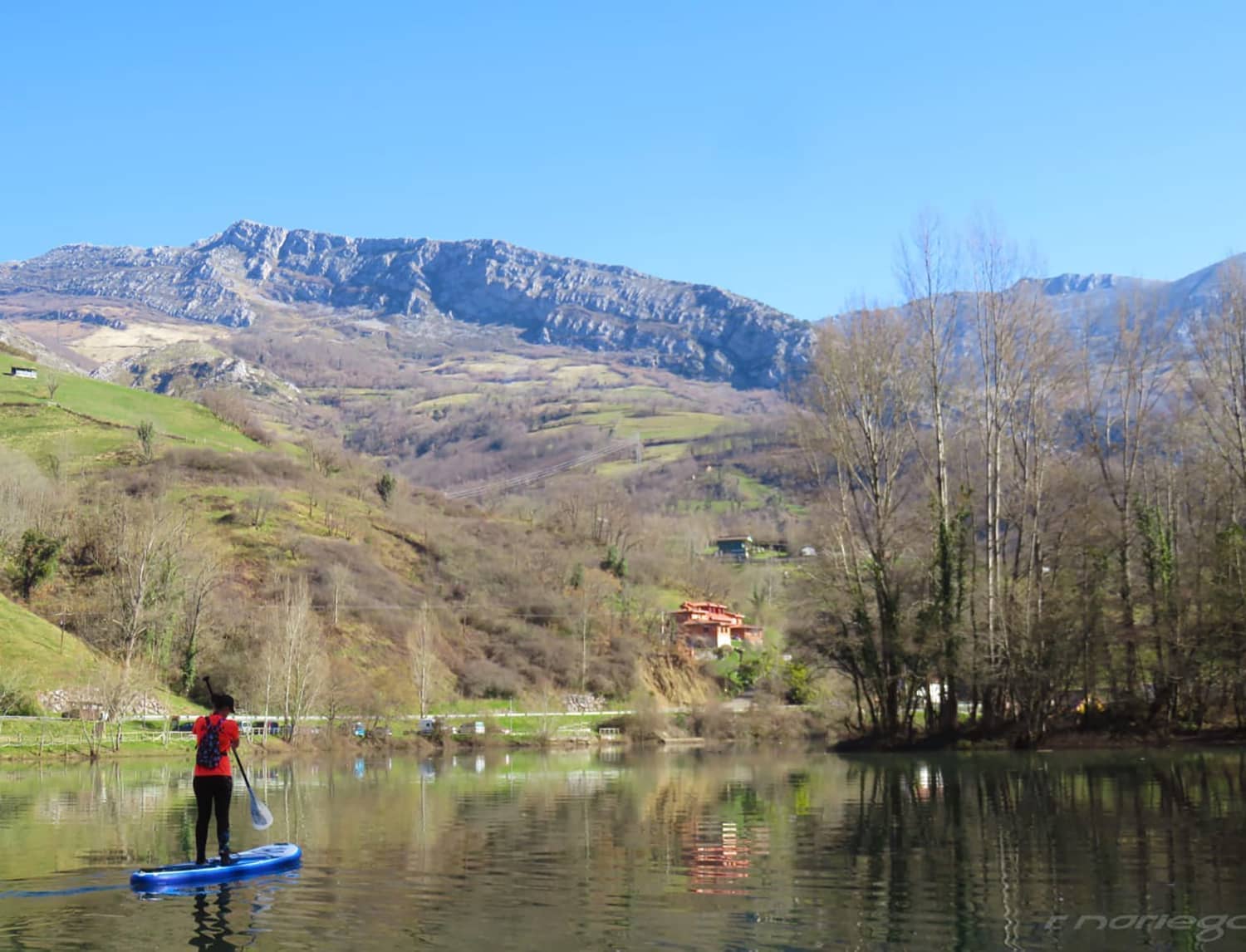 Boy paddling a Blue Evo Sup across a lake
