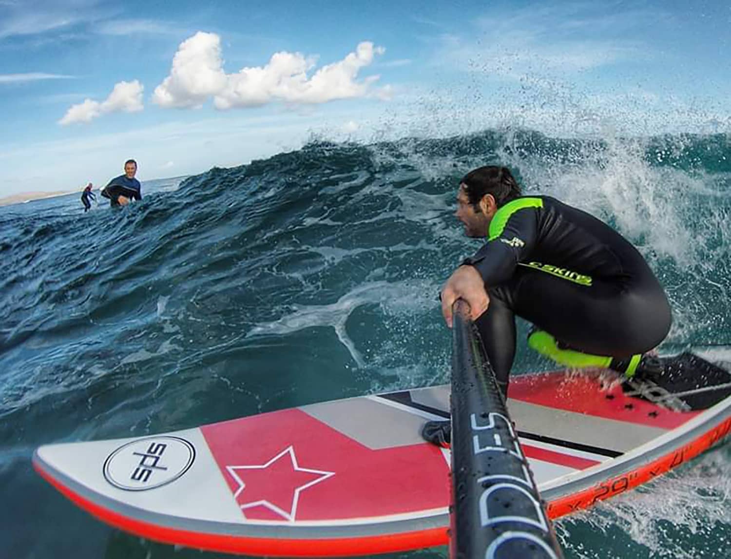 Surfista con una tabla wave surfeando agachado una ola