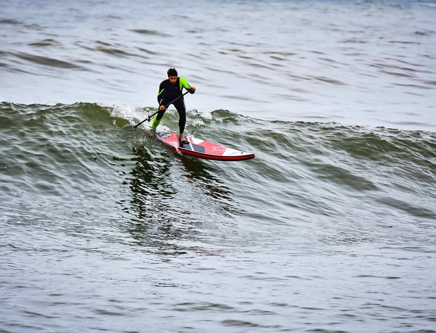 Surfista con tabla wave de SPS empezando a descender una ola